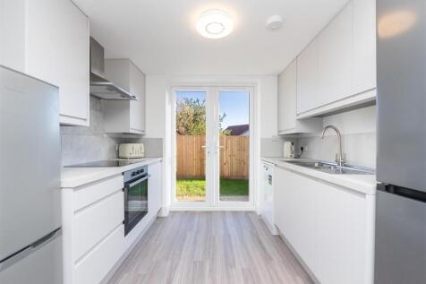 Bright and modern kitchen featuring sleek white...