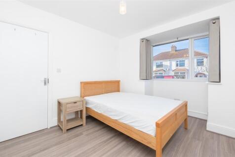Bright and tidy double bedroom featuring a wood...