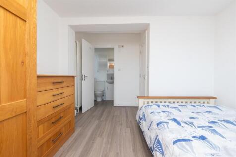 A bright and tidy single bedroom featuring ligh...