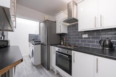 A modern and clean kitchen featuring white cabi...