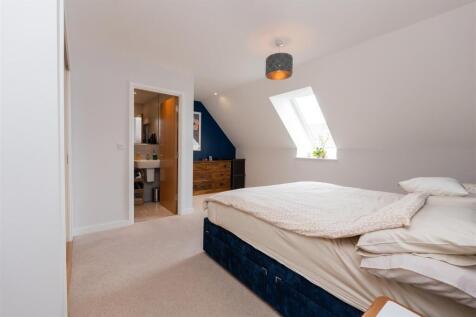 A bright and cozy master bedroom featuring a la...