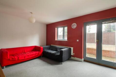 A stylish living room featuring a vibrant red s...