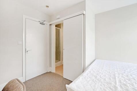 A clean and bright single bedroom featuring neu...