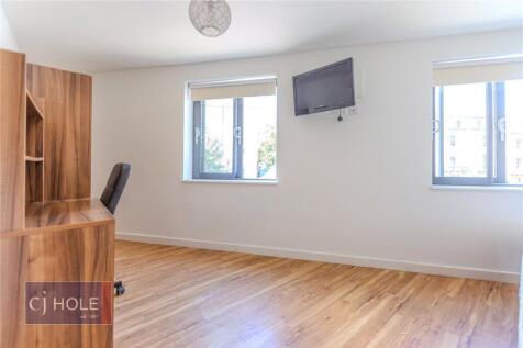 A bright and tidy single bedroom featuring two ...