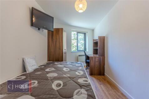A neat and well-lit single bedroom featuring a ...