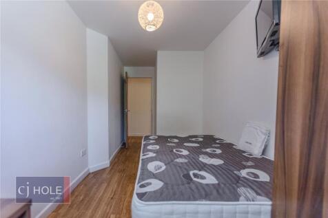 A neat and simple bedroom featuring a single be...