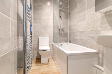Modern, bright bathroom suite featuring a full-...