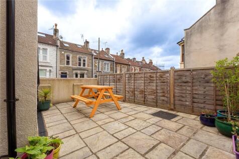 A well-maintained paved garden patio featuring ...