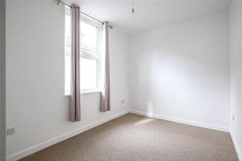 A clean and bright single bedroom featuring neu...