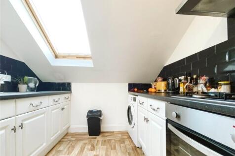A bright and modern kitchen featuring white cab...