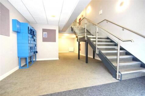 A clean and well-lit hallway featuring a carpet...
