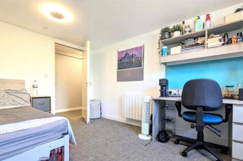 A neat and well-lit single bedroom featuring a ...