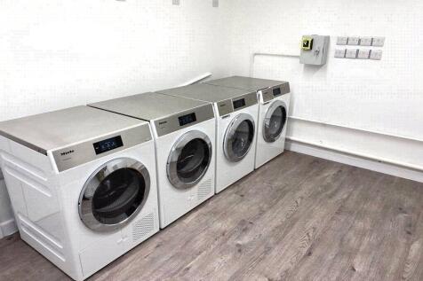Bright and tidy laundry room featuring four mod...