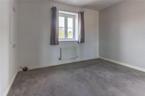 A simple and neat bedroom featuring a large win...