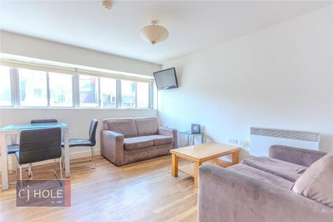 Bright and airy living room featuring large win...