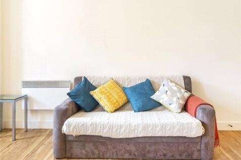 A bright and simple living room featuring a com...
