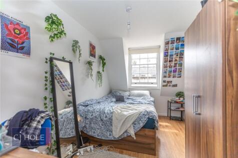 A bright and cozy single bedroom featuring a co...
