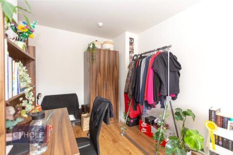 A tidy and functional single bedroom featuring ...