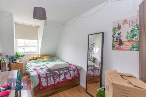A cozy single bedroom featuring a comfortable b...