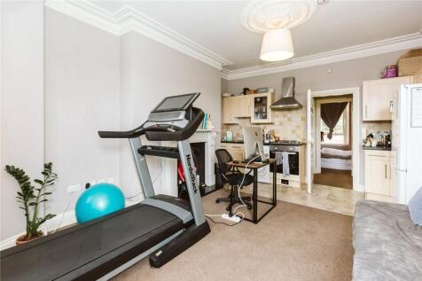 A comfortable living room featuring a treadmill...