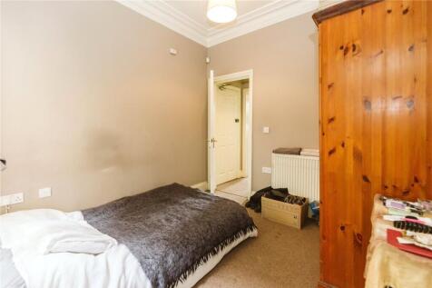 A cozy single bedroom featuring a comfortable b...