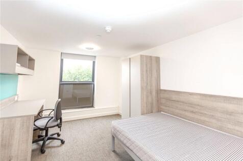 A clean and well-lit single bedroom featuring a...