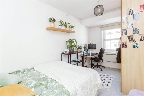 Cozy and well-organized single bedroom with a c...
