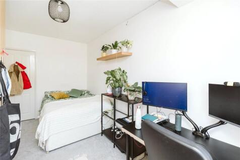 A bright and tidy single bedroom featuring a co...