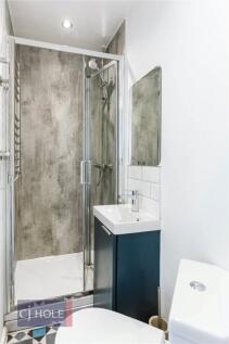 A modern bathroom featuring a clear glass showe...