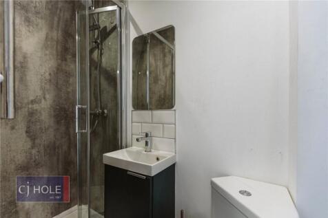 A modern bathroom featuring a glass-enclosed sh...