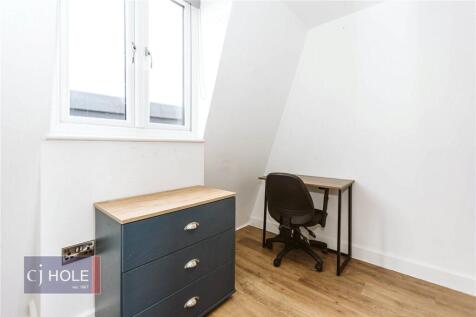 Bright single bedroom featuring a modern wooden...