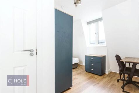 A bright and tidy single bedroom featuring ligh...