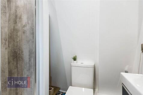A clean, modern single toilet room featuring wh...