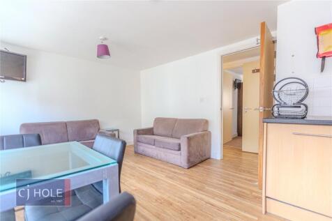 A bright and tidy living room featuring wood fl...