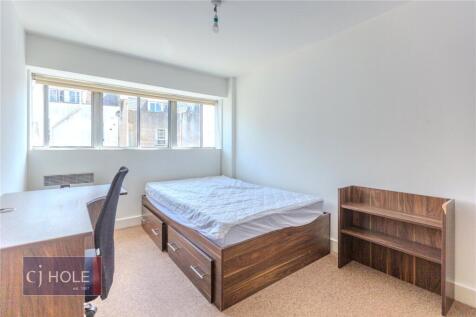 Bright and tidy double bedroom featuring a wood...