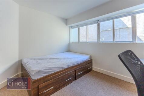 Cozy single bedroom featuring a comfortable bed...