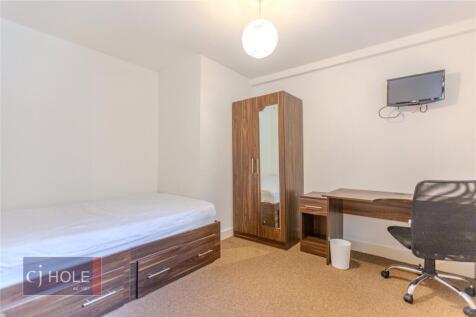 A neat and well-organized single bedroom featur...