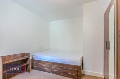 A neat and simple single bedroom featuring a wo...