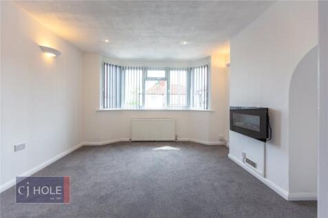 A bright and tidy living room featuring a large...