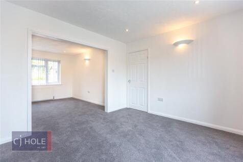 A clean and spacious living room with neutral d...