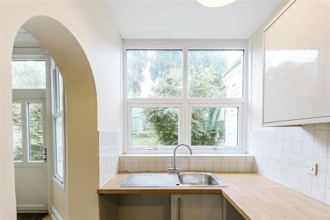 Bright and airy kitchen featuring a large windo...