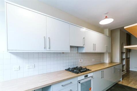 A clean and modern kitchen featuring a long woo...