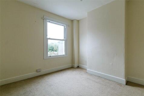 A bright single bedroom featuring a large windo...
