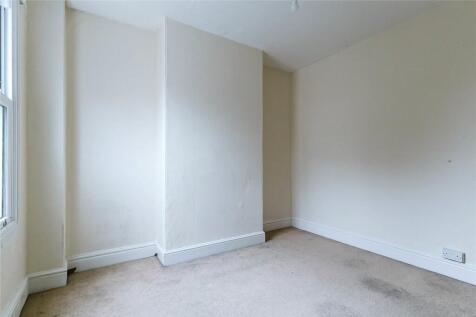 A simple, bright empty room with neutral walls ...