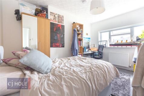 Bright and cozy bedroom featuring a comfortable...