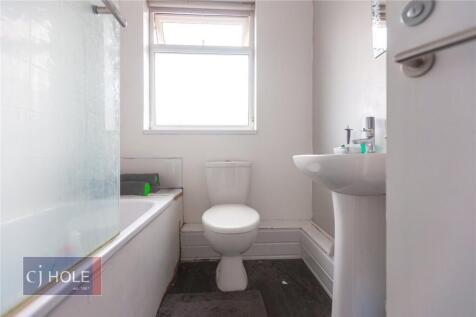 A clean, modern bathroom featuring a bathtub wi...