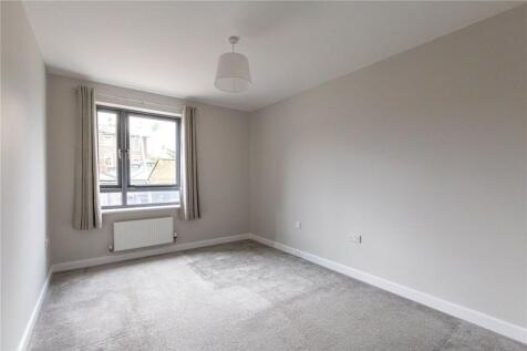 A bright and neutral double bedroom with a larg...