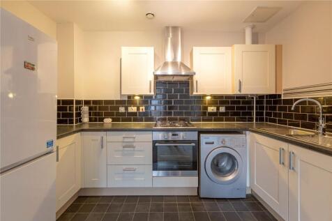 Bright and modern kitchen featuring sleek white...