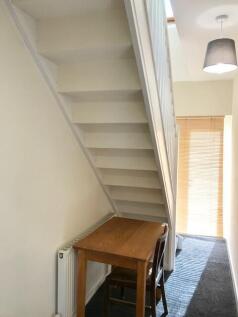 Bright hallway featuring a wooden table and cha...