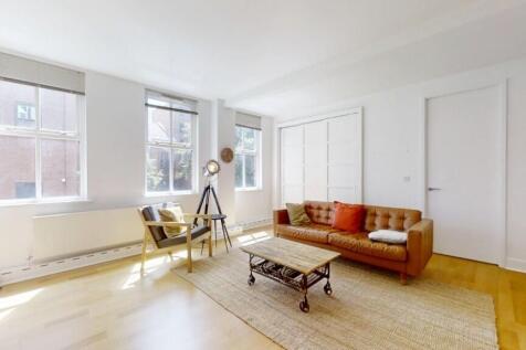Bright and airy living room featuring large win...